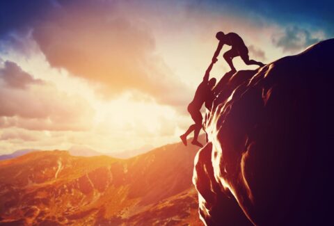 Hikers climbing on mountain. Help, support, assistance in a dangerous situation