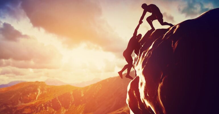 Hikers climbing on mountain. Help, support, assistance in a dangerous situation