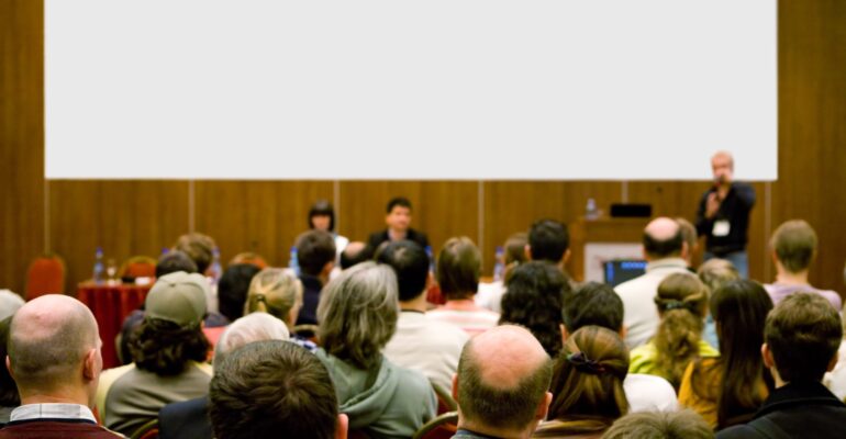 conference hall full of people participating